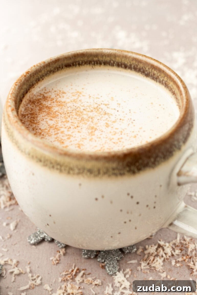 A steaming mug of warm vanilla milk, topped with a sprinkle of cinnamon, perfect for a cozy winter evening.