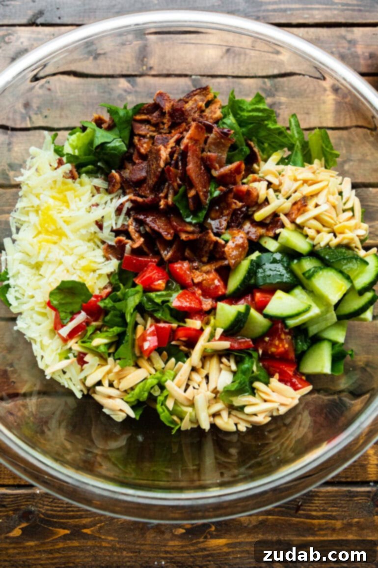 The Ultimate House Salad Recipe 5 A large glass bowl filled with all the vibrant ingredients for Salad de Maison, meticulously layered but not yet tossed, showcasing the freshness and variety of components before they become a harmonious dish.