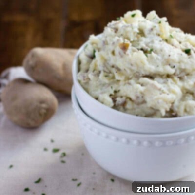 Easy Steakhouse Smashed Potatoes Recipe Close-up of fluffy Steakhouse Smashed Potatoes, garnished with fresh herbs.