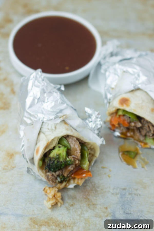 Easy and Customizable Teriyaki Beef Wraps Teriyaki Beef Wrap ready to be served, showing the ingredients nestled in a tortilla with a side of sesame seeds