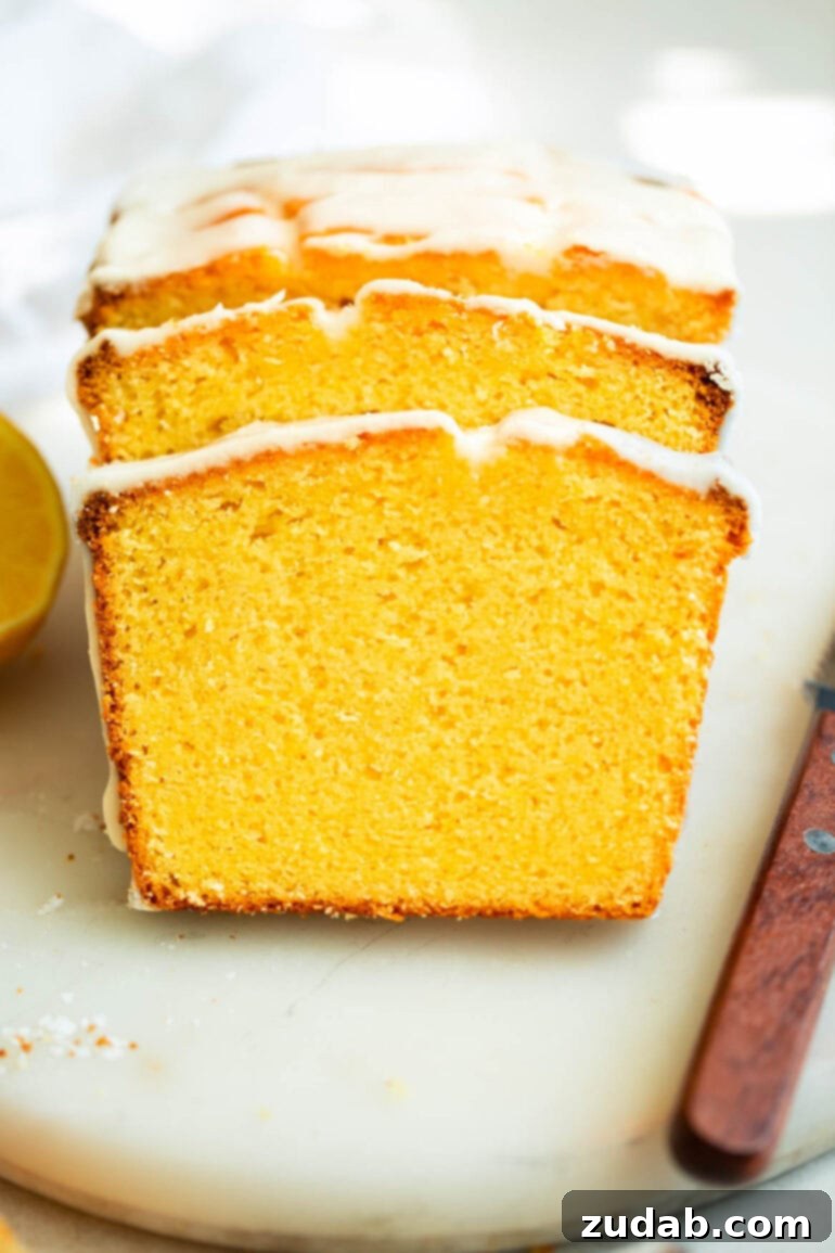 Zesty Lemon Glaze Loaf 8 a photo of slice of moist dense lemon pound cake topped with a white glaze