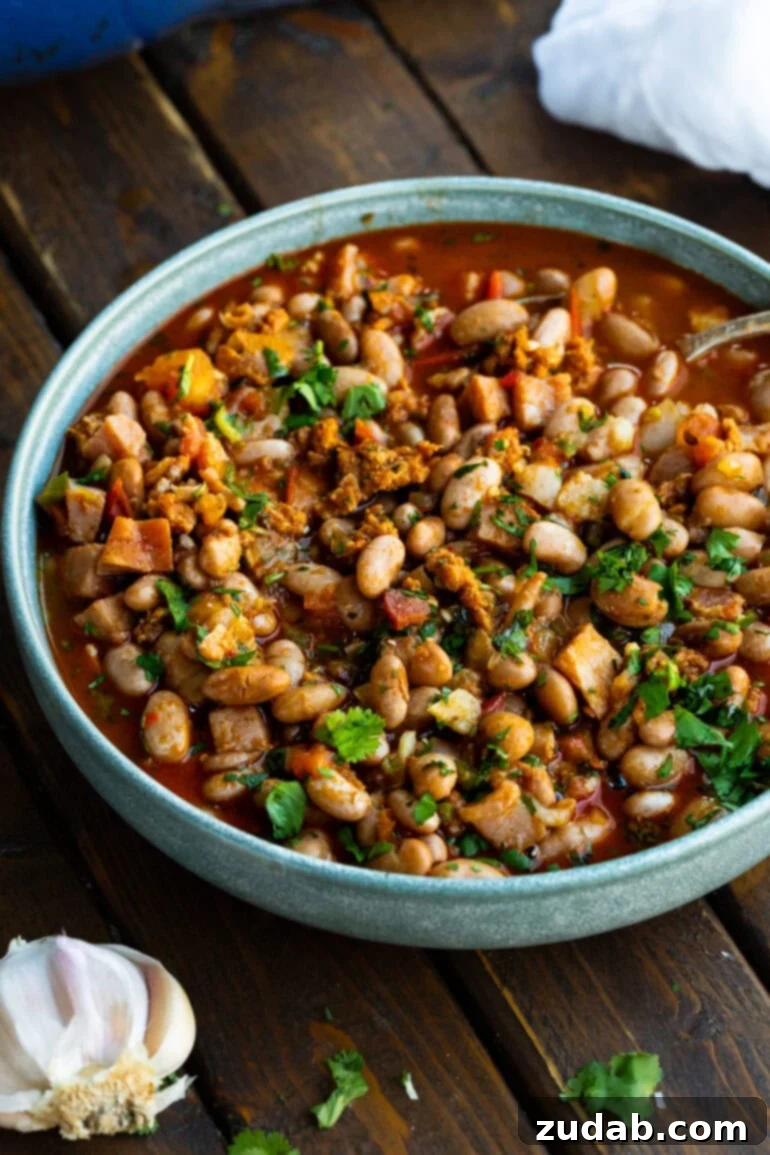 Classic Charro Beans Recipe 2 A large bowl of authentic charro beans, garnished generously with fresh chopped cilantro, ready to be served.