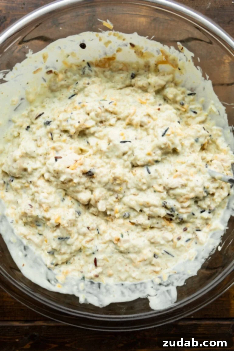 Creamy Dream Chicken & Rice Bake 5 A large mixing bowl filled with the creamy chicken and rice casserole mixture, ready to be transferred into a baking dish for cooking.