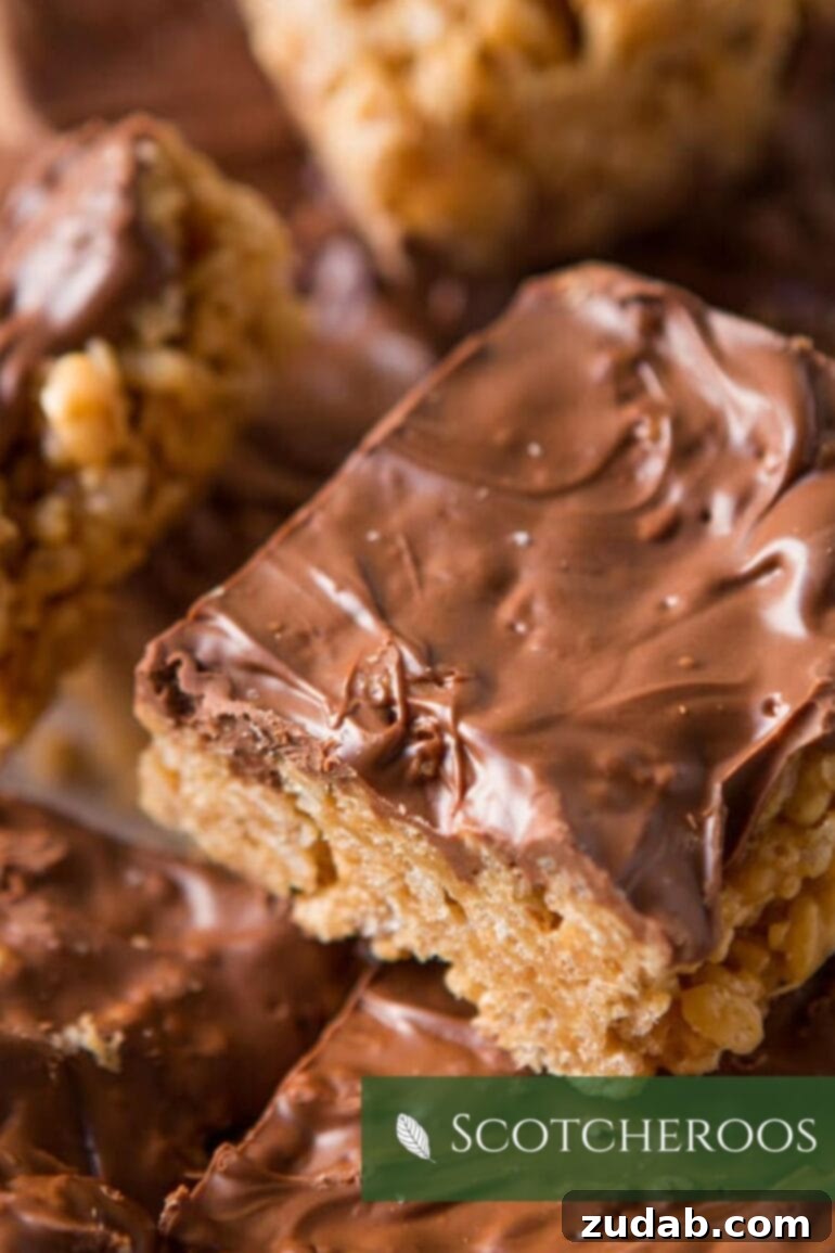 A close-up of a creamy, chocolate-covered peanut butter Scotcheroo, showcasing its rich layers and irresistible texture.
