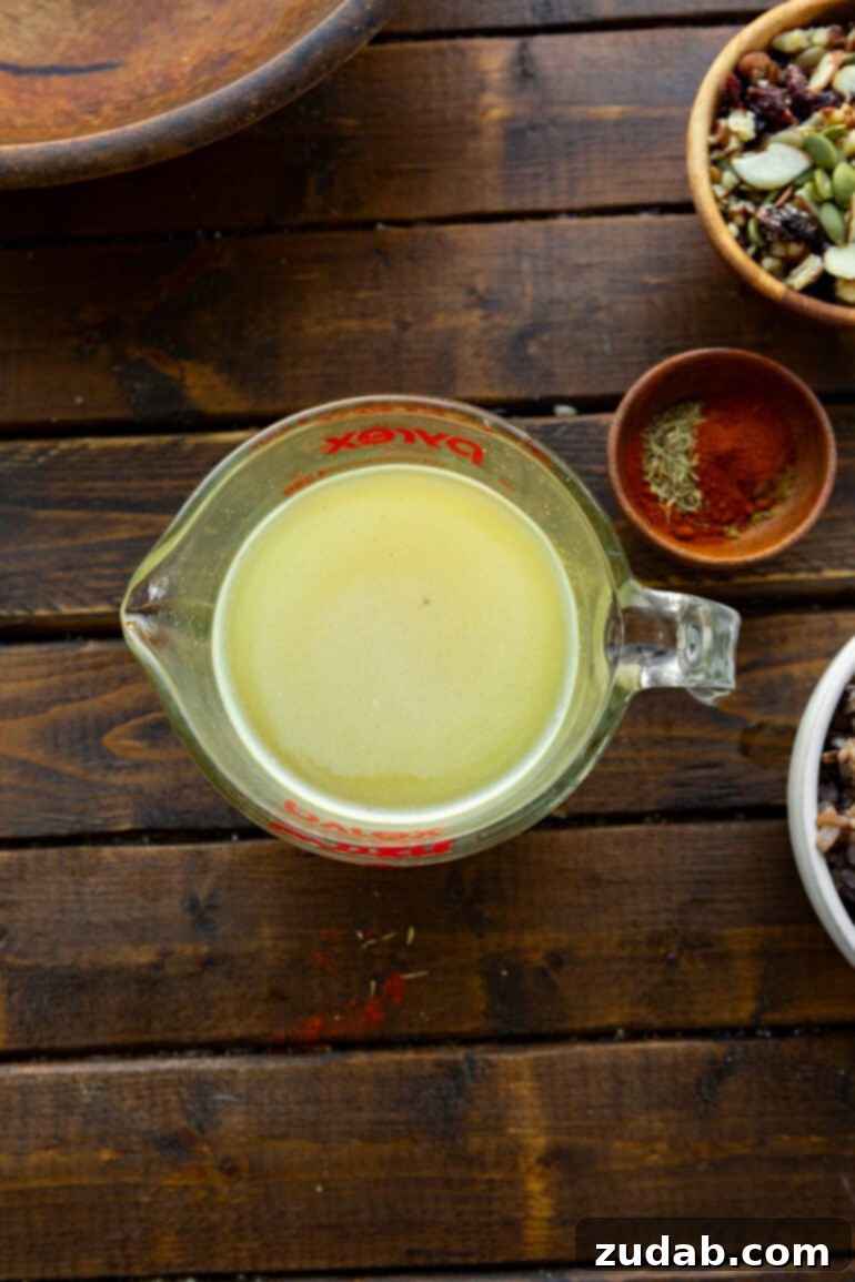 Nourishing Chicken Harvest Bake 5 A glass measuring cup filled with creamy honey mustard dressing, ready to be incorporated into the casserole