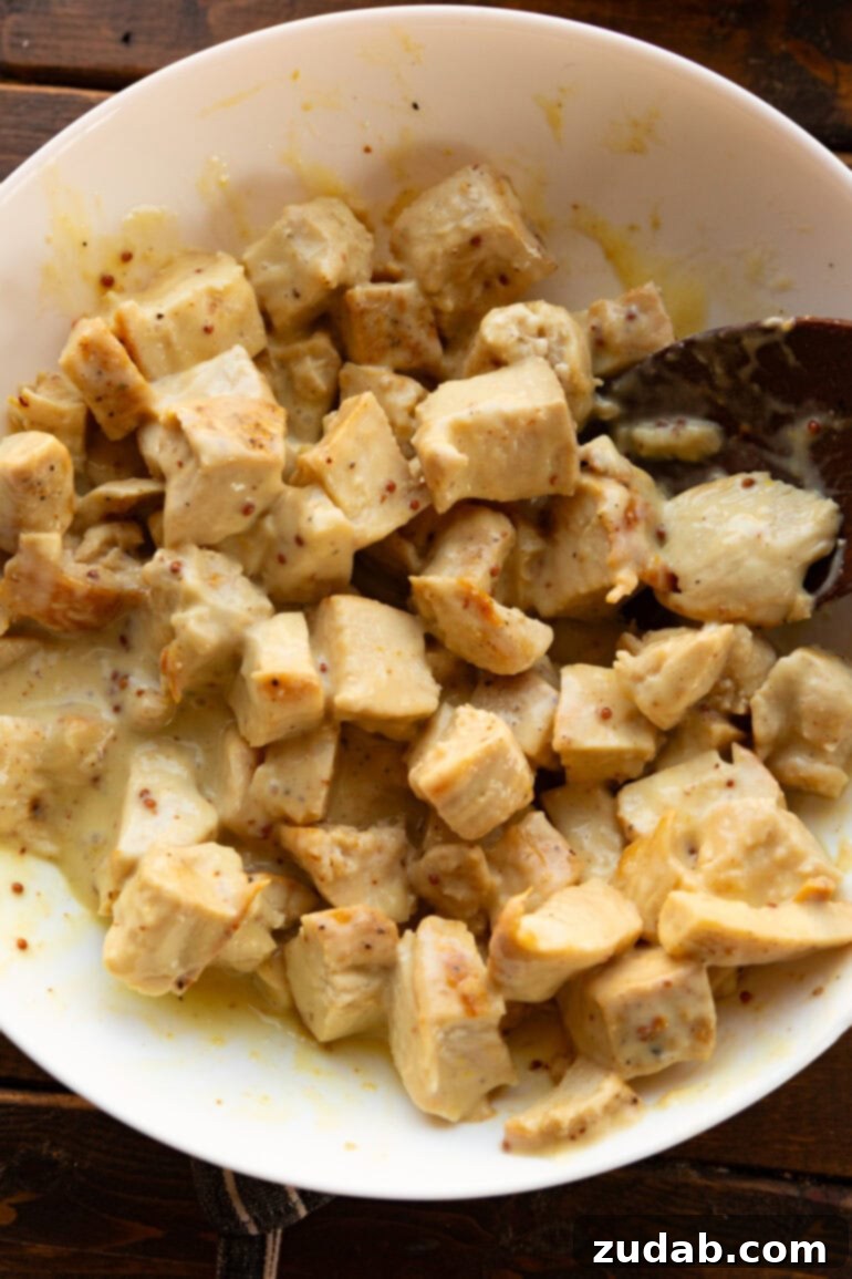 Nourishing Chicken Harvest Bake 6 Close-up of chunks of chicken breast searing in a large skillet, ready to be added to the casserole
