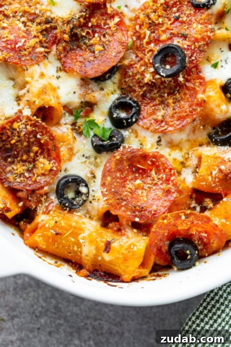 One-Pan Pizza Night Delight 12 a photo of a casserole dish full of baked pizza casserole topped with sliced olives and melted mozzarella cheese
