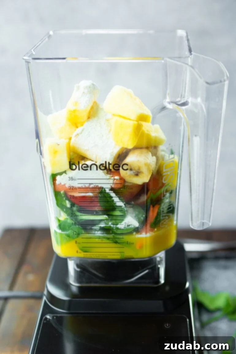 The Ultimate Cold-Busting Green Smoothie 5 A photo of a Blendtec blender filled with all the vibrant ingredients for a cold buster green smoothie, ready to be blended into a powerful health drink.