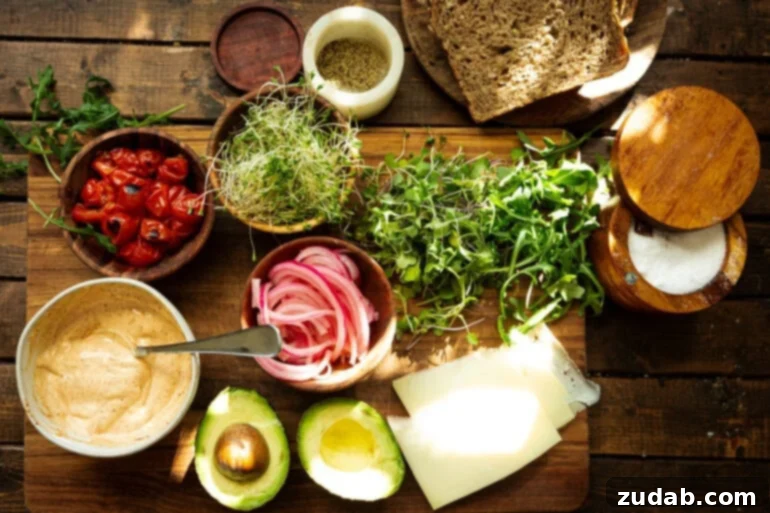 My Signature Avocado Sandwich 4 A colorful array of fresh ingredients for the ultimate avocado sandwich, including sliced avocado, creamy Manchego cheese, vibrant microgreens, perfectly charred cherry tomatoes, peppery arugula, and a bowl of homemade spicy mayo.