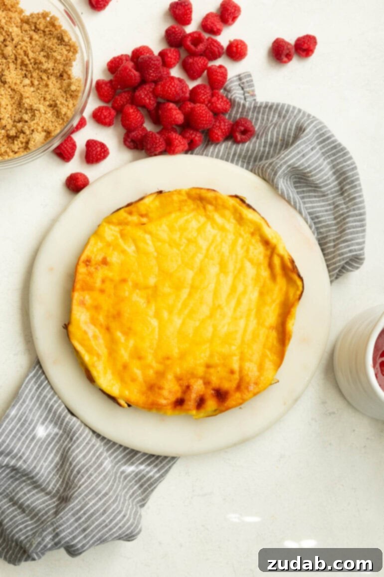 Baked Yogurt Cheesecake 4 A golden-brown, freshly baked yogurt cake sitting on a white cutting board, cooling before toppings are added.