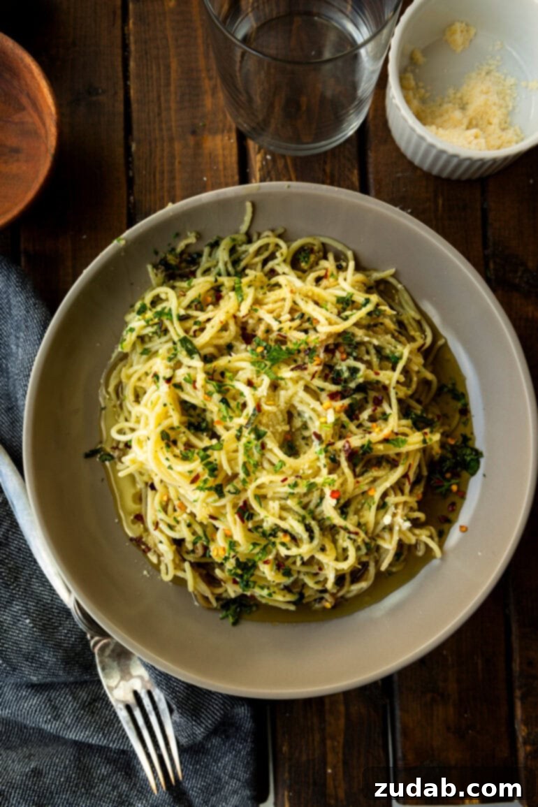 Flavorful Aglio e Olio Made Easy 6 A large serving bowl brimming with spaghetti aglio e olio, generously topped with Parmesan cheese and fresh herbs