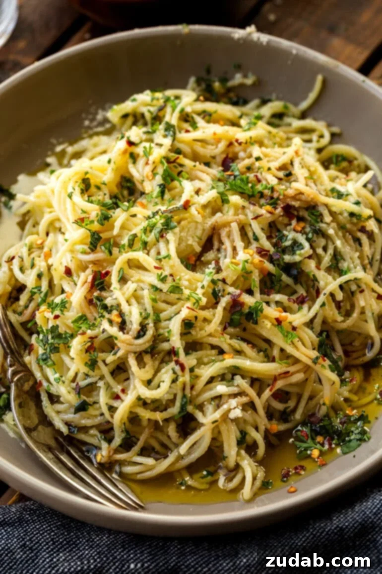 Flavorful Aglio e Olio Made Easy 8 A close-up photo of spaghetti tossed with fresh herbs, olive oil, and grated Parmesan cheese