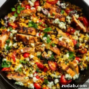 A finished plate of Greek Chicken and Lemon Rice with feta and herbs.