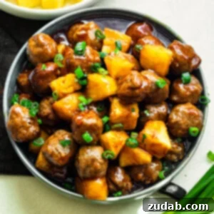 Slow Cooker Island Glazed Meatballs 9 A large serving bowl of saucy Hawaiian meatballs mixed with pineapple chunks and topped with chopped green onions