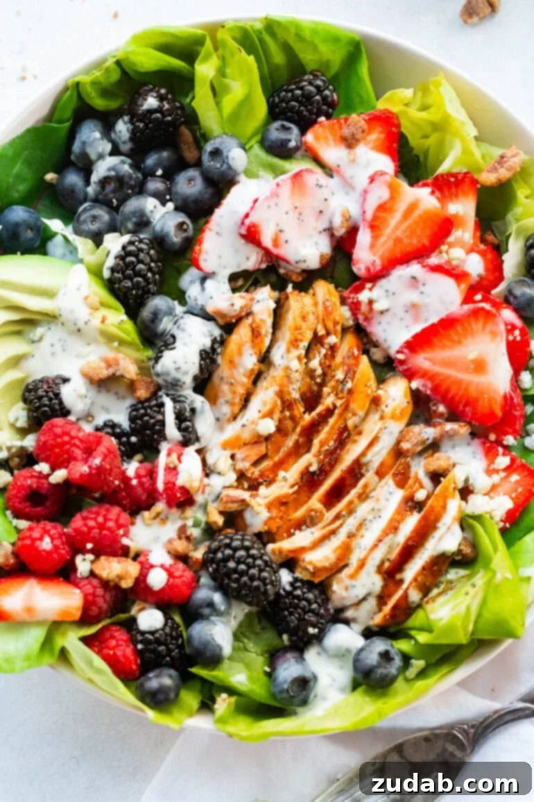 Fresh & Fit Berry Avocado Chicken Salad 2 A large serving bowl full of Berry Avocado Chicken Salad with strips of seasoned chicken breast, fresh berries, sliced avocado, and a creamy poppyseed dressing.