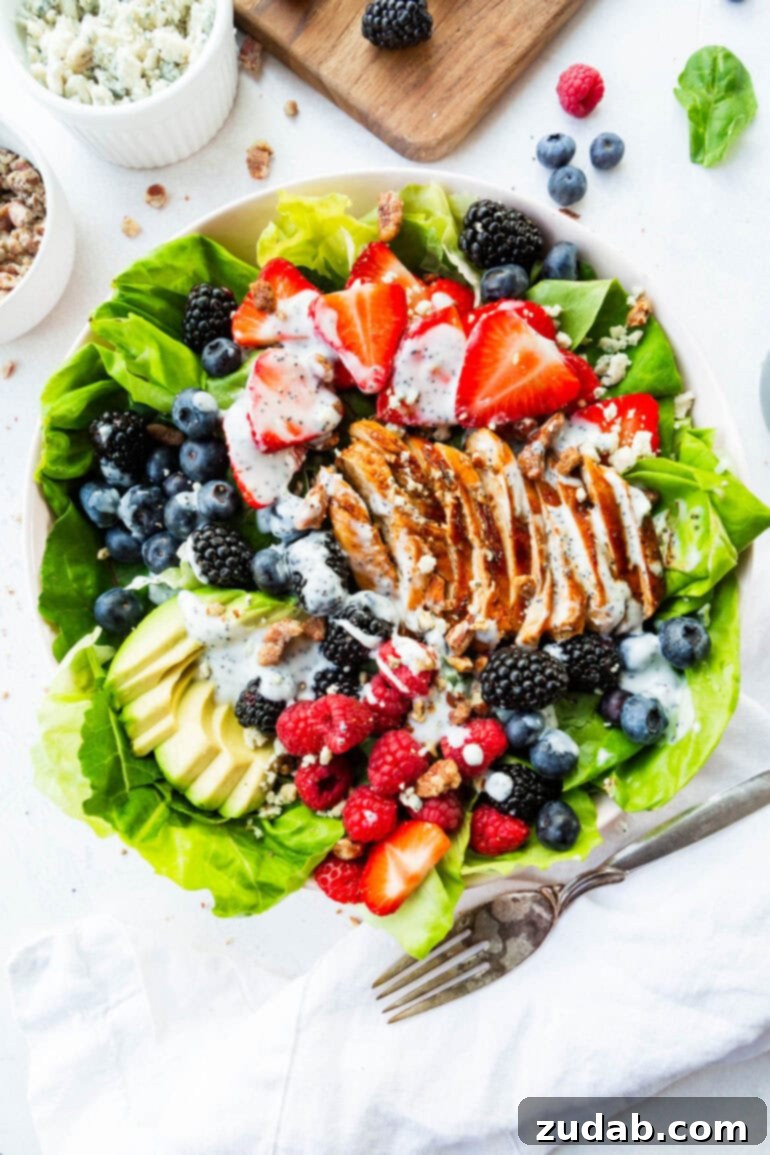 Fresh & Fit Berry Avocado Chicken Salad 7 A beautifully arranged bed of butter lettuce, generously topped with an array of fresh strawberries, raspberries, blackberries, and blueberries, alongside perfectly sliced chicken breast, creamy avocado, and a delicate drizzle of poppyseed dressing.