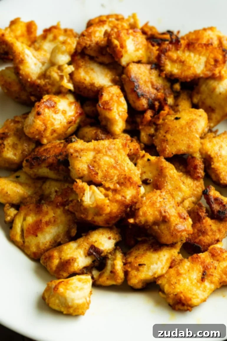 One-Pan Mexican Elote Chicken 6 A plate of chicken pieces, lightly breaded and seasoned, ready to be pan-fried.