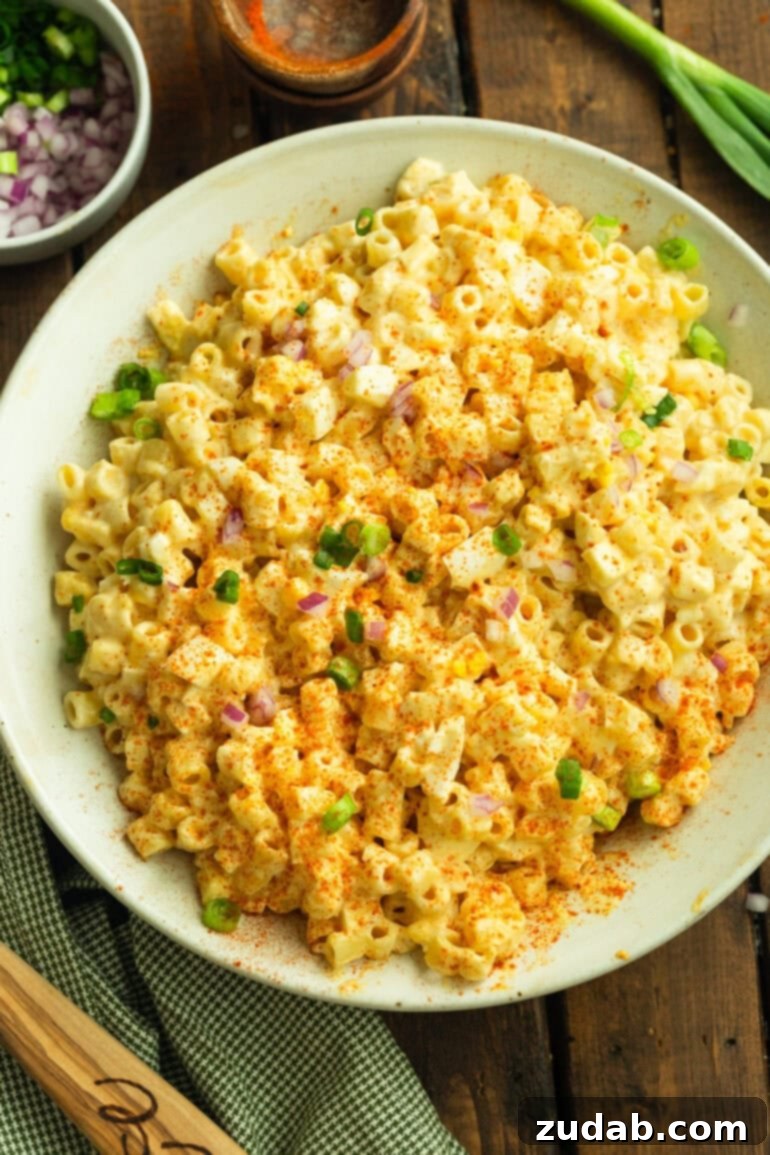 Zesty Deviled Egg Pasta Salad 2 a photo of a large serving bowl of creamy deviled egg pasta salad topped with chopped chives