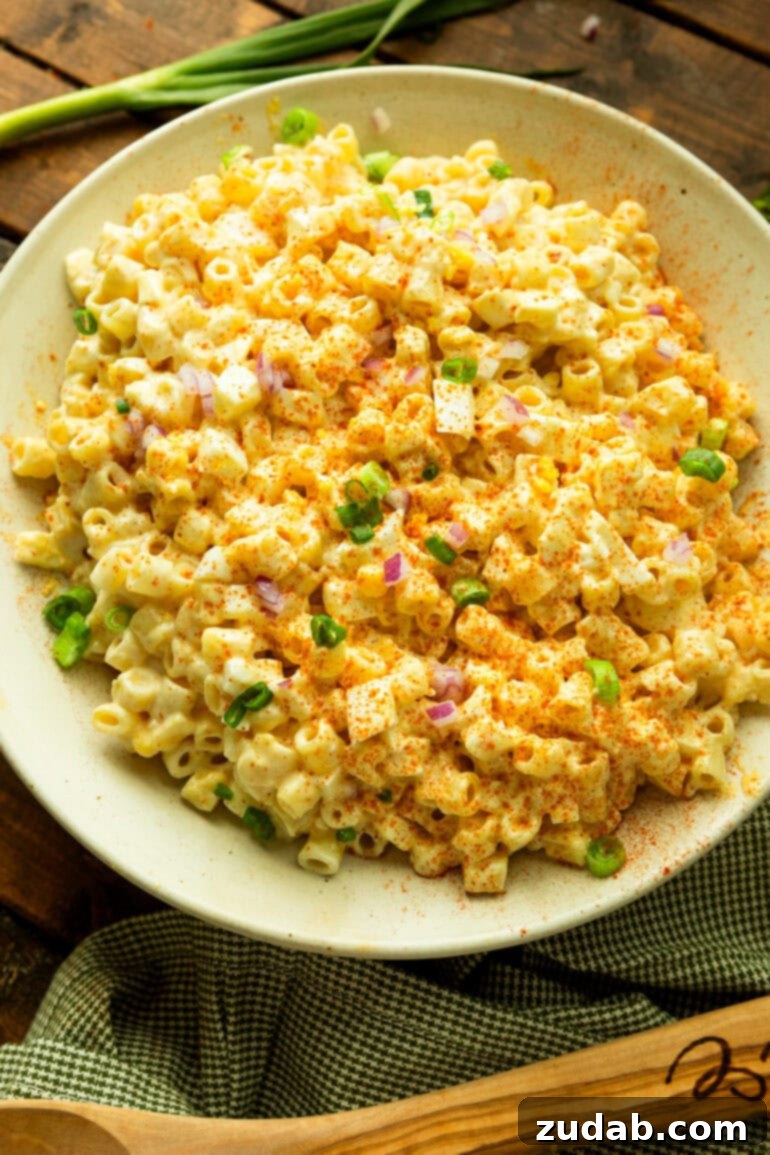 Zesty Deviled Egg Pasta Salad 7 a photo of a deviled egg pasta salad topped with green onions and diced red onions