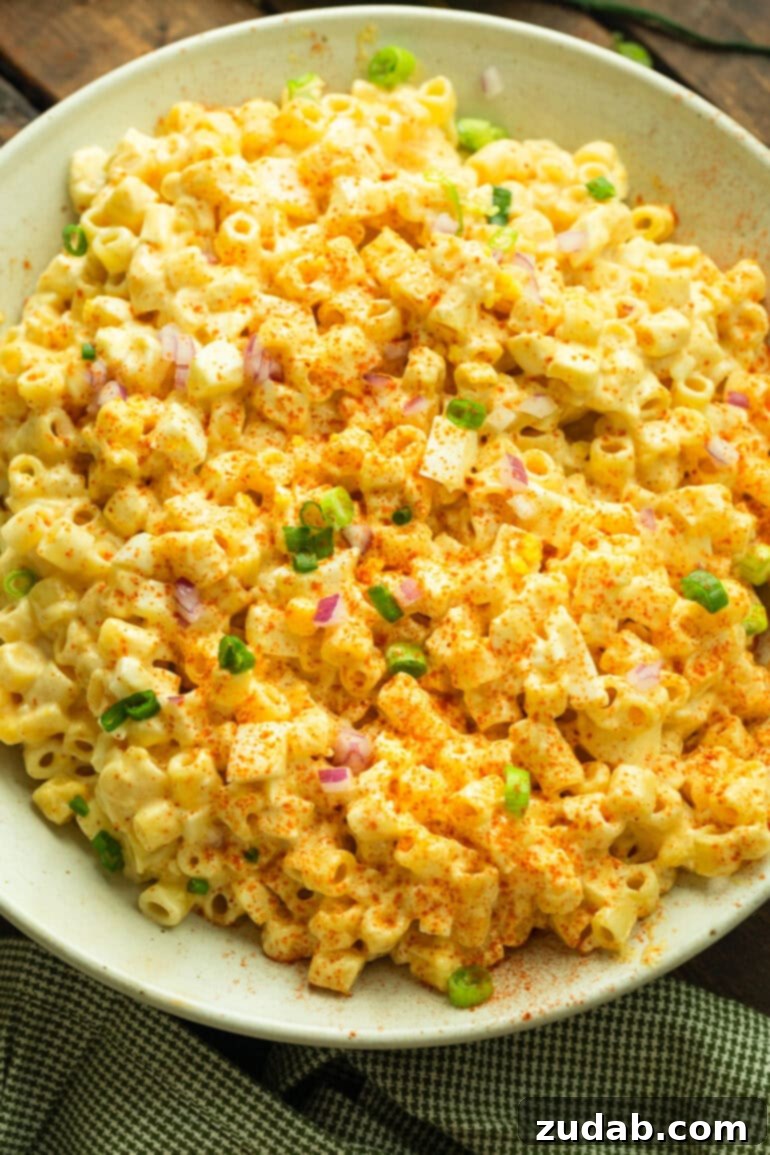 Zesty Deviled Egg Pasta Salad 8 a photo of a creamy deviled egg pasta salad topped with diced green onions and red onions