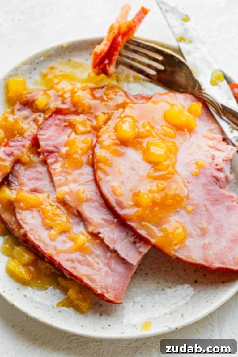 Your New Favorite Slow Cooker Ham 3 a photo of several slices of cooked ham topped with a pineapple glaze