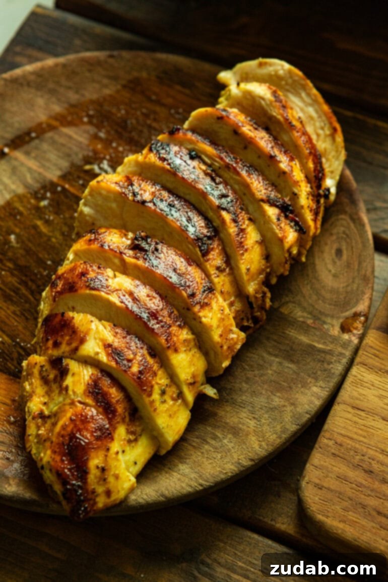 Summer Grilled Chicken Salad with Creamy Basil Dressing 7 a photo of a sliced grilled chicken breast sitting on a wooden plate