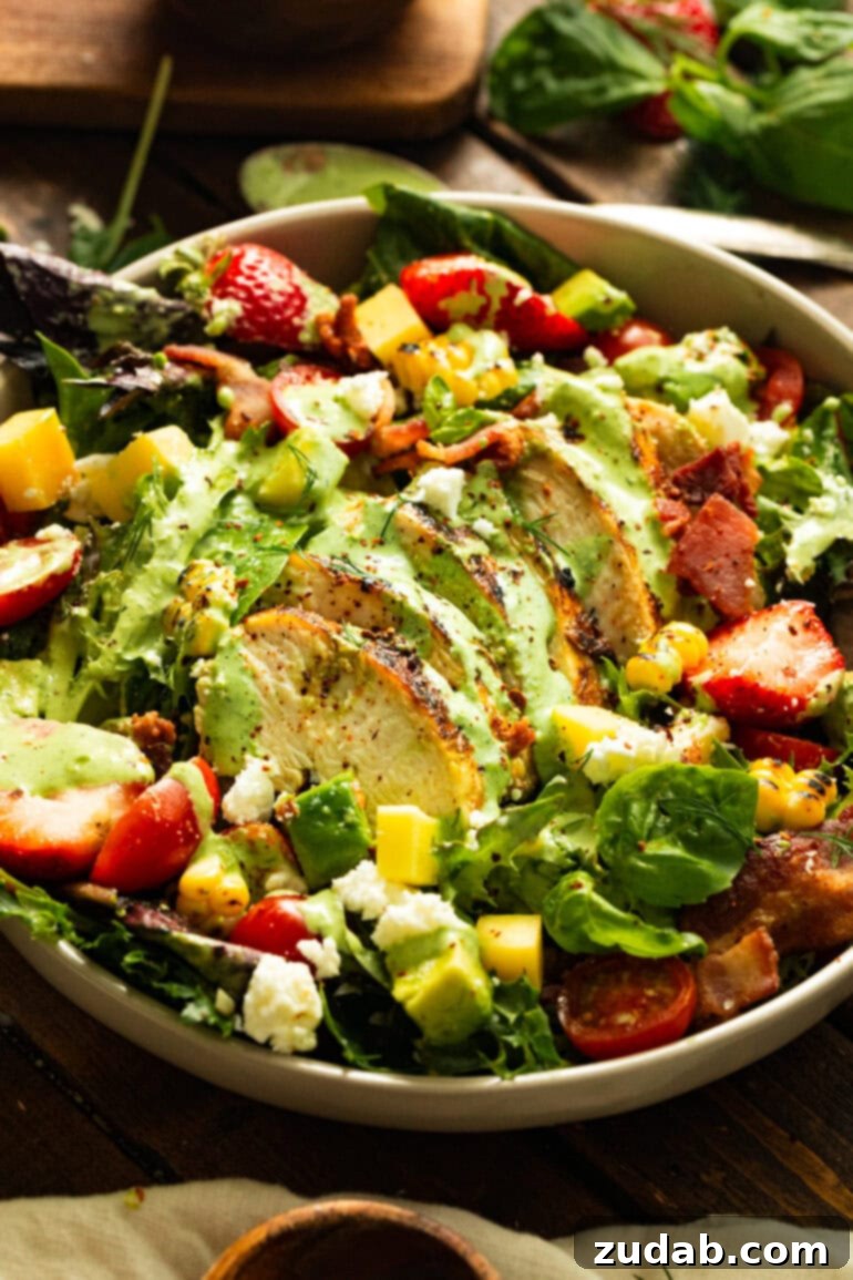Summer Grilled Chicken Salad with Creamy Basil Dressing 9 a photo of grilled sliced chicken breasts on top of a colorful summer salad drizzled with homemade basil dressing