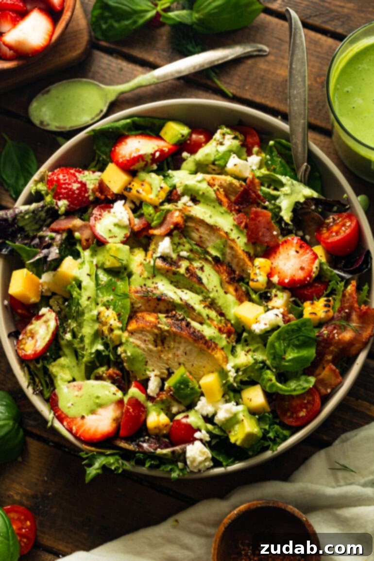 Summer Grilled Chicken Salad with Creamy Basil Dressing 10 a photo of a grilled chicken salad with strawberries, bacon, grilled corn and cheese topped with basil dressing