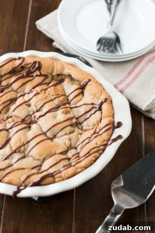 Reese's Peanut Butter Marshmallow Cookie Pie - Decadent Dessert Reese's Peanut Butter Marshmallow Cookie Pie, garnished with mini Reese's cups and chocolate drizzle, perfect for sharing.