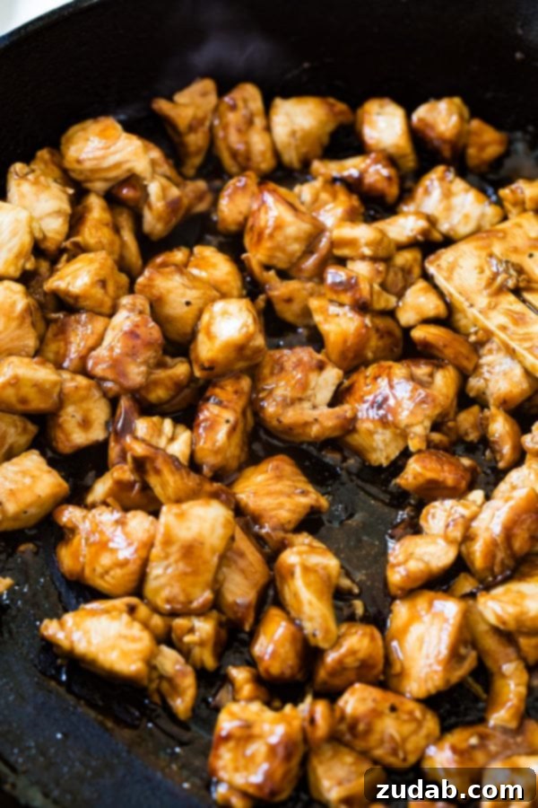 A photo of teriyaki chicken being cooked in a skillet.