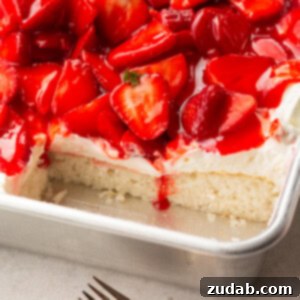 A photo of a single layer white cake topped with cream cheese frosting and juicy red strawberries with some slices removed so you can see the cross section, perfect for a summer dessert.