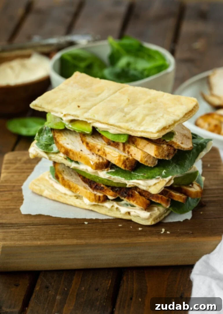 Zesty Grilled Chicken Avocado Stack 2 A photo of a double stacked grilled chicken and avocado napoleon sandwich, showcasing its elegant layers and fresh ingredients, perfectly plated for a gourmet experience.