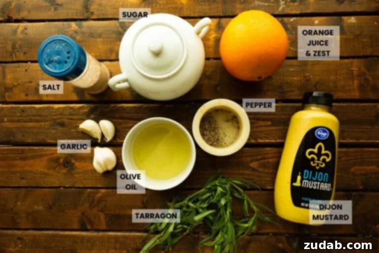 Sun-Kissed Citrus Grilled Chicken Marinade 3 Flat lay of key ingredients: garlic cloves, olive oil, pepper, Dijon mustard, fresh tarragon, an orange, and a teapot, arranged on a rustic wood surface.