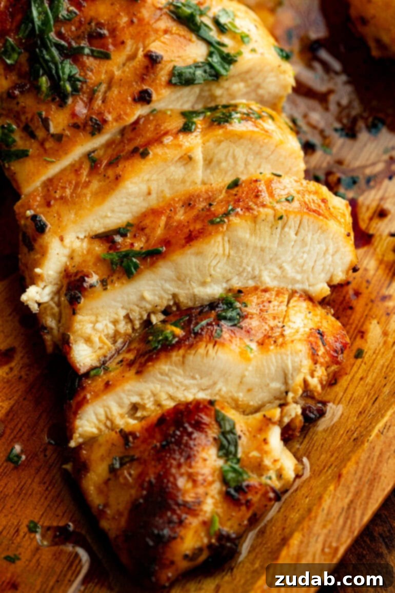 Sun-Kissed Citrus Grilled Chicken Marinade 5 Sliced citrus-marinated grilled chicken breast showing juicy, tender interior with charred grill marks and herbs on top.