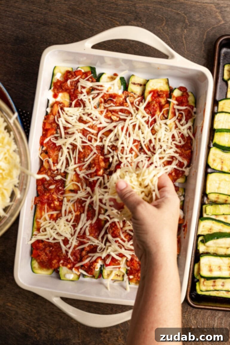 Perfect Zucchini Lasagna No Soggy Layers 11 Sprinkling mozzarella and Parmesan.