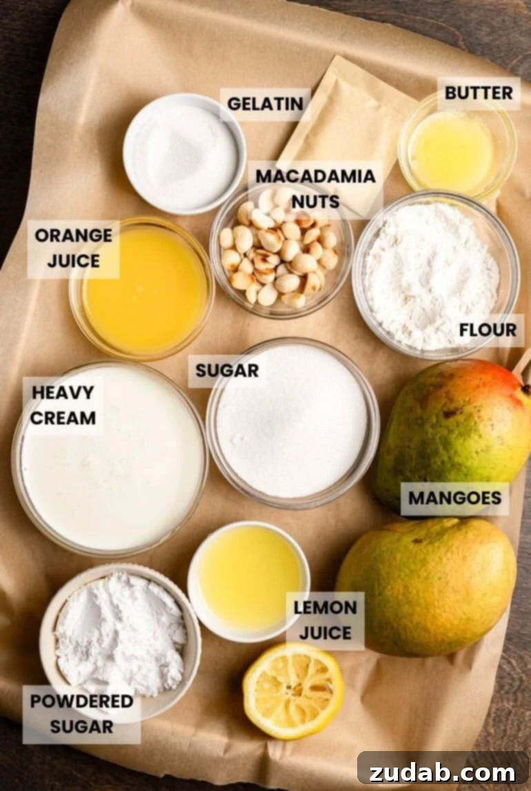A flat lay of all the fresh ingredients needed to make frozen mango dessert with macadamia nut crust, including whole mangoes, macadamia nuts, butter, sugar, and cream, neatly arranged on brown parchment paper.