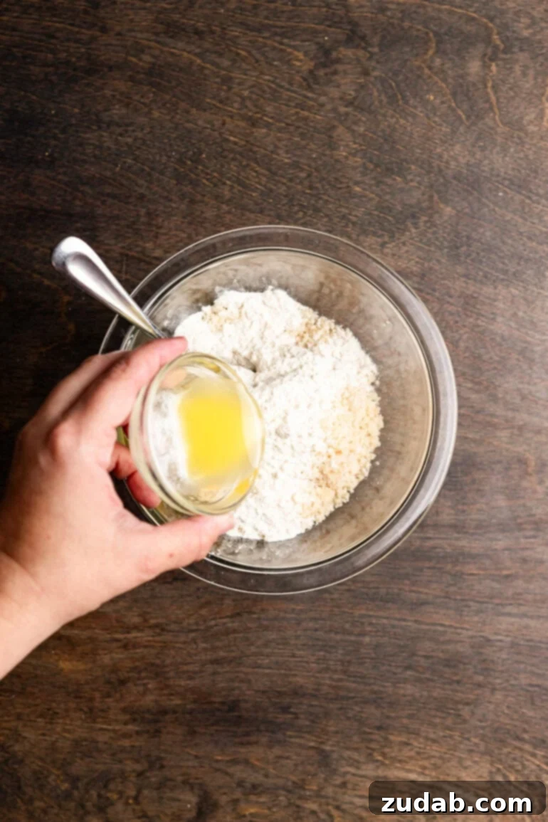 Step 3: Mixing the macadamia nut crumbs with flour and melted butter.