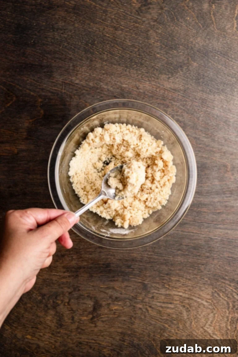 Step 4: Pressing the macadamia nut crust mixture into the bottom of a ring mold.