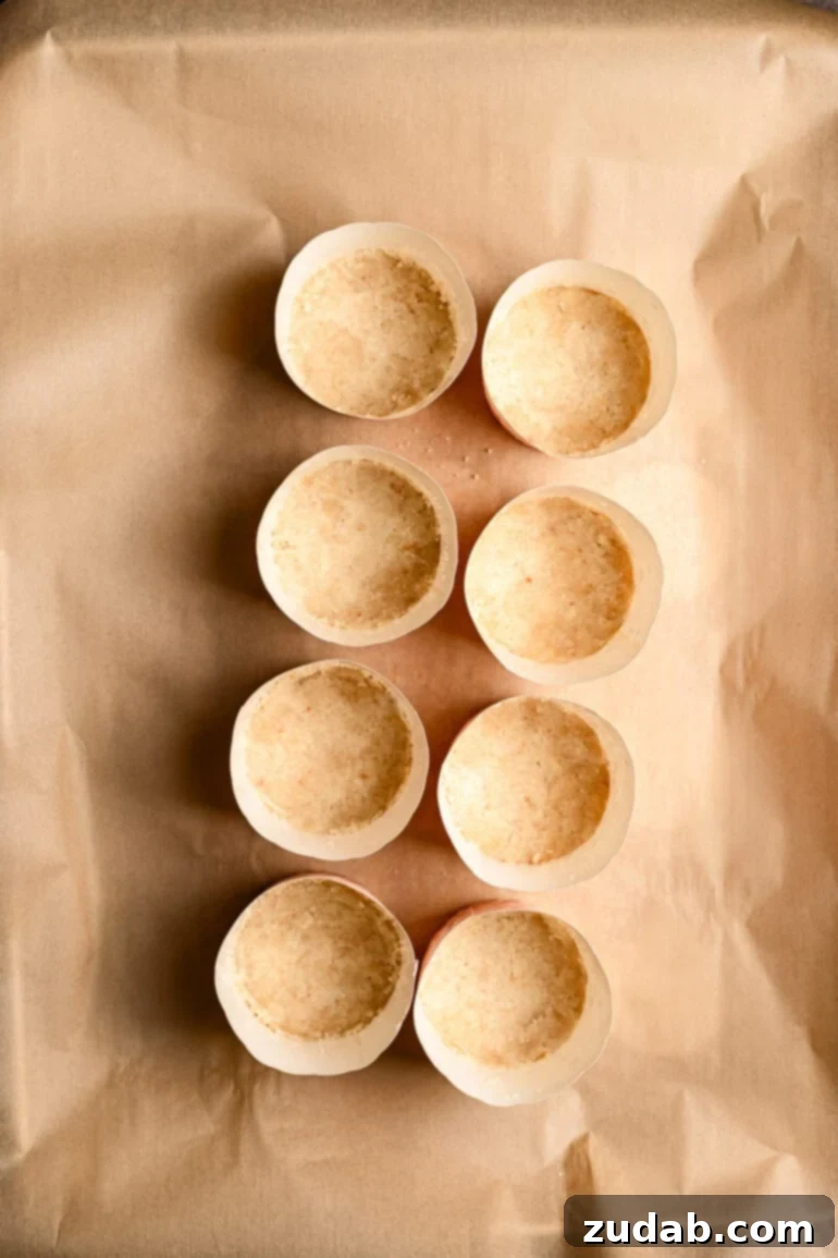 Step 5: Baked macadamia nut crusts cooling on a parchment-lined baking sheet.