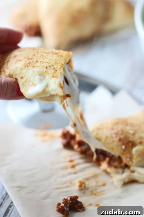 Cheesy Lasagna Calzones with ground sirloin Close-up of a stack of Cheesy Lasagna Calzones, showing the golden crust