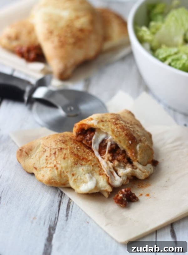 Cheesy Lasagna Calzones with ground sirloin A delicious Cheesy Lasagna Calzone, served on a plate and ready to eat