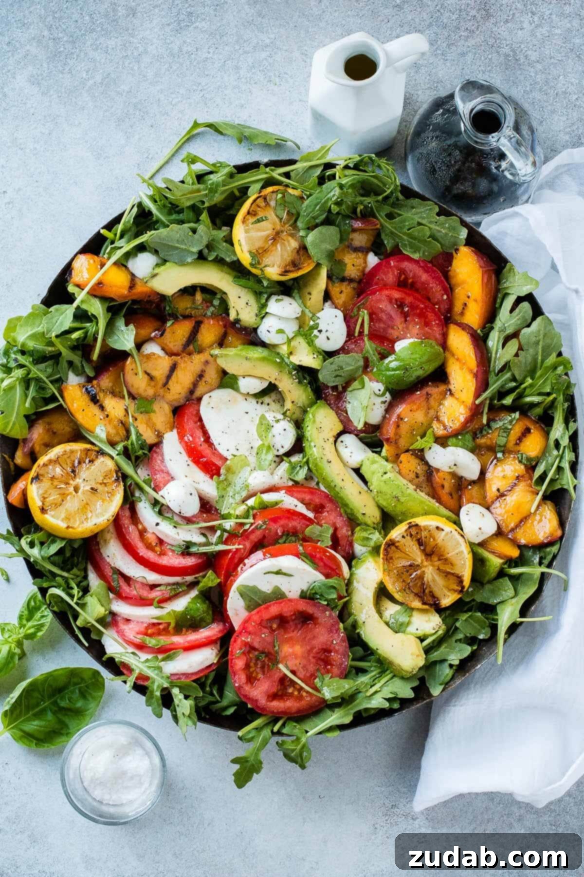 Grilled Peach Caprese 4 How to make a grilled peach avocado caprese salad with balsamic reduction. A close-up shot showing fresh ingredients arranged artfully on a platter, highlighting the vibrant colors and textures.
