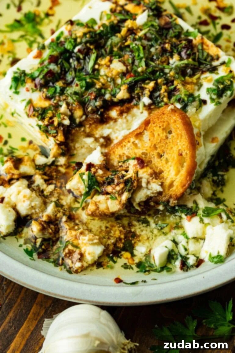 a crostini dipped into a creamy herb feta dip