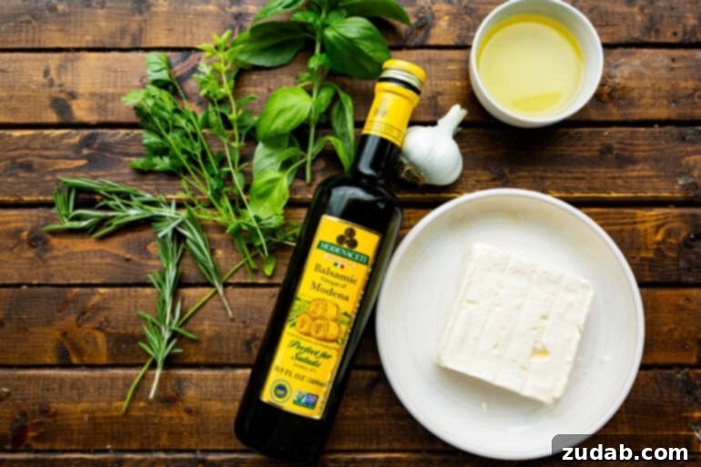 a crunchy crostini being dipped into a block of feta cheese covered with herby olive oil