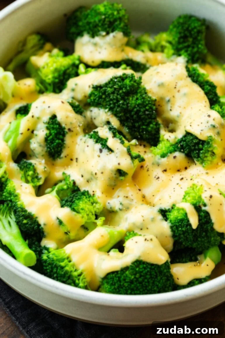 creamy cheddar cheese sauce poured over freshly steamed broccoli sprinkled with black pepper