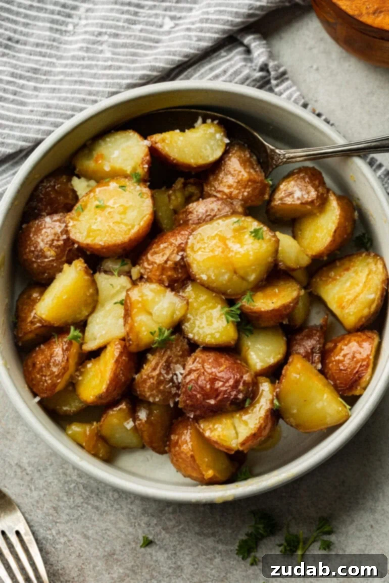 Golden Roasted Red Potatoes 3 A minimalist white bowl presents a serving of tender, golden roasted red potatoes, each piece beautifully seasoned and cooked to perfection, highlighting their appealing texture.