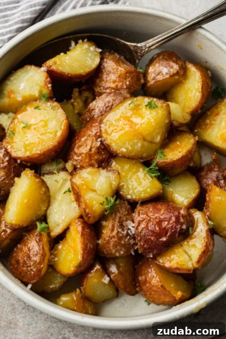 Golden Roasted Red Potatoes 5 A simple white bowl holds a serving of tender, fluffy potatoes with perfectly crisp, golden outsides, their inviting texture and color prominently displayed.
