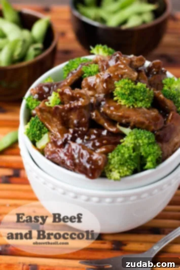 Sticky Honey Garlic Crispy Chicken 5 beef and broccoli in a white bowl next to two small wooden bowls with peas on a wooden table.