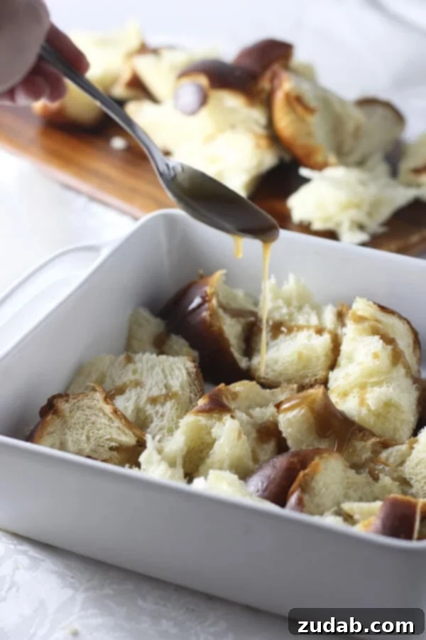 Gooey Caramel Cinnamon Roll Baked French Toast Casserole for breakfast or brunch Close-up of Gooey Caramel Cinnamon Roll Baked French Toast Casserole with layers of challah bread, caramel, and cinnamon sugar