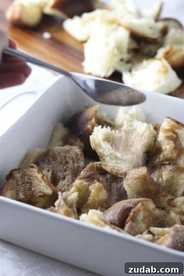 Gooey Caramel Cinnamon Roll Baked French Toast Casserole for breakfast or brunch Serving a piece of Gooey Caramel Cinnamon Roll Baked French Toast Casserole, showcasing the fluffy texture and rich caramel drizzle